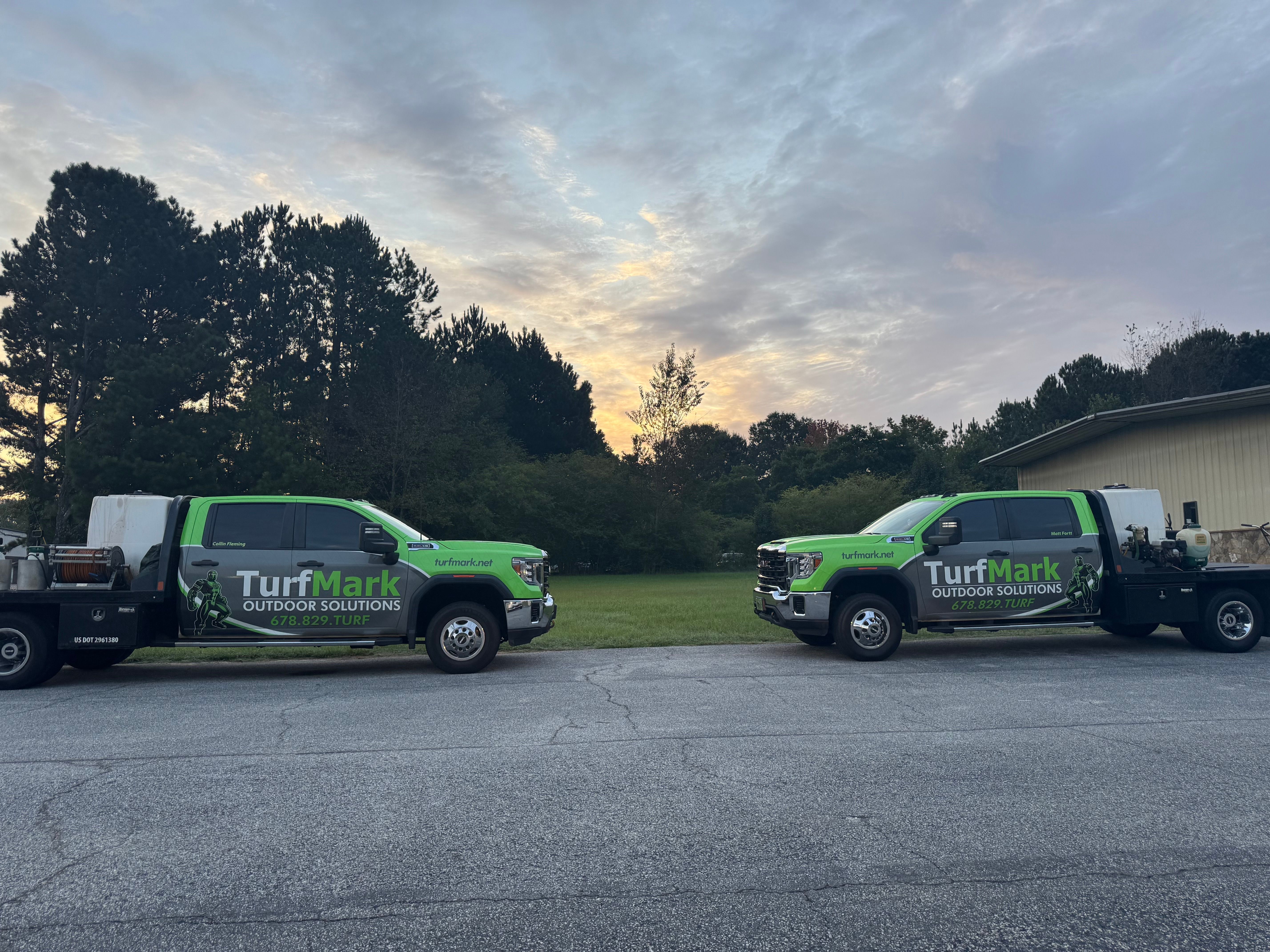 TurfMark’s green and black trucks lined up at the Buford shop at dusk