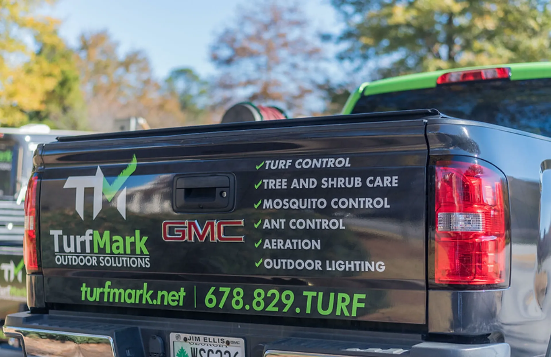 The tailgate of a TurfMark truck listing turf control, tree and shrub care, mosquito control, ant control and aeration