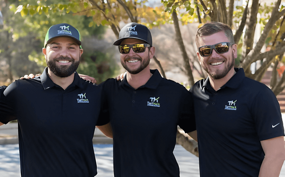 Three members of the TurfMark team in black company polos